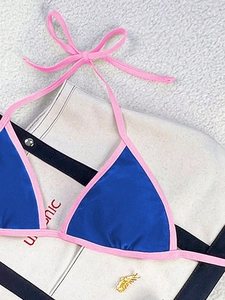 Detail of color-block bikini top featuring royal blue fabric and pink lace-up straps