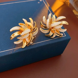 Detailed shot of vintage gold-plated floral earrings on a luxury jewelry box