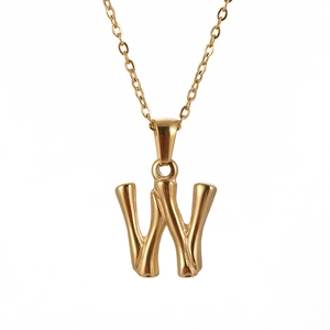Detailed close-up of golden bamboo texture necklace featuring letter W pendant