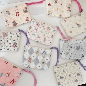 Detail of floral quilted cotton makeup bags with cute cartoon prints and zip closure