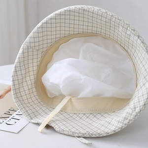 Detailed interior view of plaid sun hat showing adjustable drawstrings and white lining