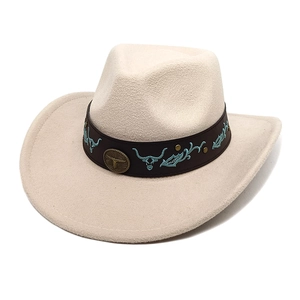 Détail du chapeau de cowboy en feutre beige avec broderie et emblème bronze