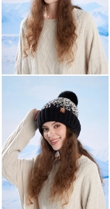 Detailed knit pattern and faux fur pompom on a winter beanie with leather logo patch