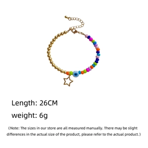 Detail showing colorful beaded bracelet with gold star pendant and evil eye bead charm