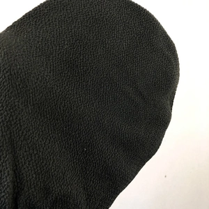 Macro shot of the black coarse-grained texture on exfoliating bath mitt material