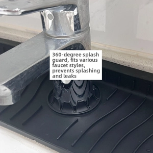 Close-up of black silicone faucet splash guard with drainage grooves on marble surface