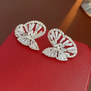 Nahaufnahme glitzernder Schmetterlingsohrringe mit Zirkonia auf einer roten Box