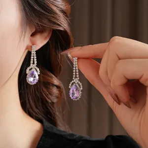 Luxurious silver drop earrings with purple pear-shaped stones and shimmering zirconia