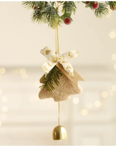 Detail of plush Christmas tree ornament with golden bell and a Christmas label tag