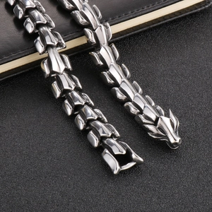 Macro detail of silver dragon bone chain featuring dragon head and secure clasp design