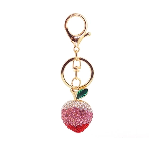Cute pink gradient rhinestone peach keychain with gold metal base and green leaf detail