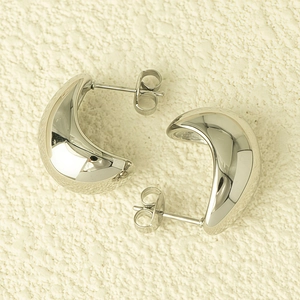 Détail des boucles d'oreilles créoles demi-cercle en acier titane poli au fini argenté