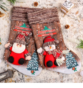 Détail d'une chaussette de Noël en peluche avec figurines 3D Père Noël et bonhomme neige