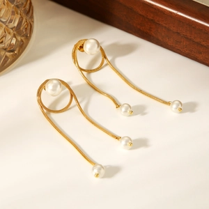 Detailed close-up of golden snake chain tassels with white pearls on earrings