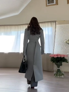 Rear view of a grey long slim-fit wool coat featuring an elegant belt and button design