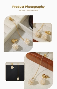 Detailed view of asymmetric earrings with natural freshwater pearl clusters in gold finish