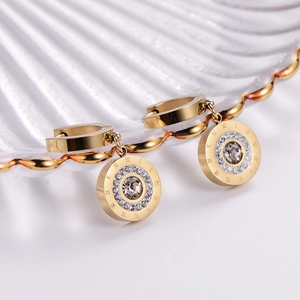 18k gold plated roman numeral stud earrings with crystal center on a white shell plate