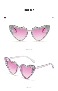Detail view of heart-shaped sunglasses with purple gradient lenses and rhinestone frames