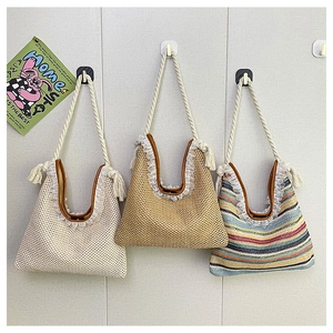 Three stylish woven straw tote bags with lace trim and rope handles hanging on hooks