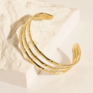 Detailed view of golden 18K gold plated C-shaped cuff with three-layer bamboo texture