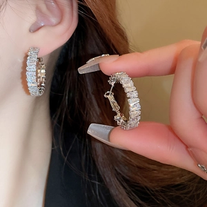 Square zircon circle stud earrings in silver finish worn by a model with a close-up detail