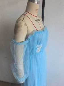 Detail eines himmelblauen Mesh-Kleides mit weißen floralen Spitzenapplikationen am Busen