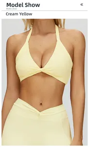 Detail view of cream yellow halter sports bra with a front twist knot on model