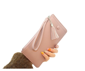 Pink long wallet with lychee texture and matching tassel charm held in hand