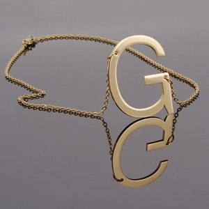 18K gold-plated stainless steel necklace with capital letter G pendant on dark surface