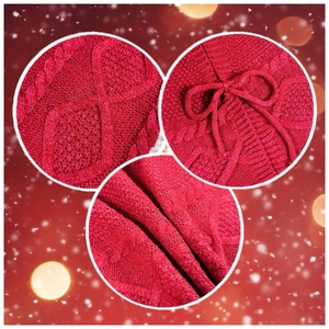 Détail de la jupe de sapin de Noël tricotée rouge avec motifs torsadés et petits nœuds