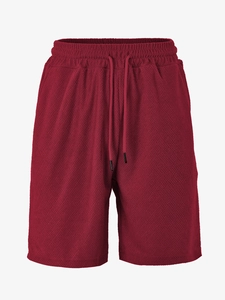 Detail of burgundy knit shorts featuring a textured honeycomb fabric and drawstring waist