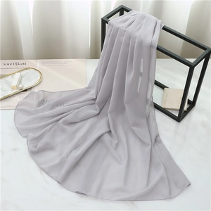 Close-up of lightweight light grey chiffon scarf draped over a black metal rack