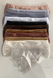 Multiple colors of satin silk panties shown in a stack with a white pair fully displayed
