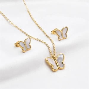 Elegant gold butterfly jewelry set including necklace and stud earrings on white silk background