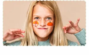 Close-up of waterproof colorful umbrella and pumpkin face stickers on a child