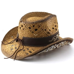 Close-up of woven straw cowboy hat featuring floral embroidery on a brown decorative band