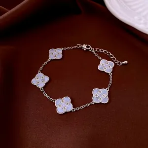 Silver flower bracelet with blue four-leaf clover charms and sparkling zircon inlay