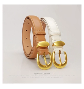 Detail of slim women's belts in caramel brown and off-white with matte gold buckles