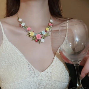 Close-up of floral necklace with colorful resin roses and pearls on a female model