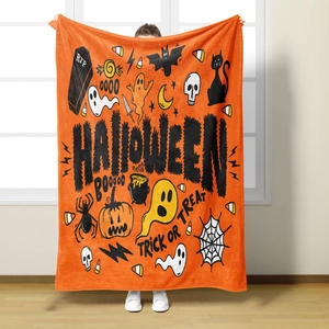 Detail of Halloween flannel blanket with pumpkin and ghost prints held by a model