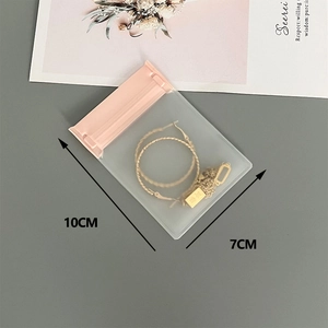 Detailed view of 10x7cm pink seal jewelry storage bag with earrings and necklace inside
