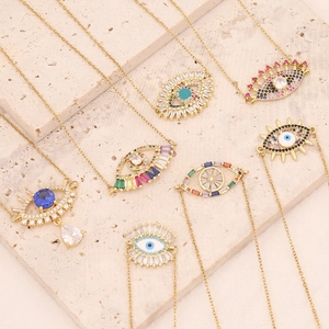 Golden Evil Eye necklaces with colorful cubic zirconia pendants on stone stand