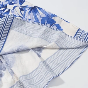 Close-up of tropical blue floral fabric with blue-white striped lining and stitching details