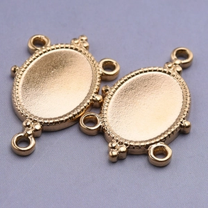 Macro shot of two 18k gold plated oval stainless steel connector charms for DIY necklaces