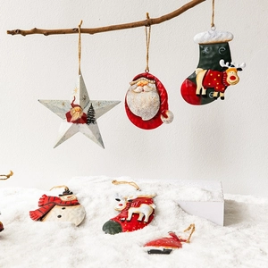 Vintage metal Christmas tree ornaments featuring Santa and snowman in a snowy scene