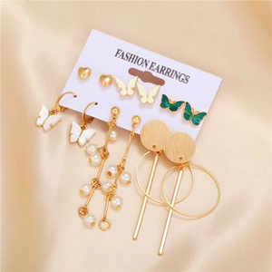 Detail of 6-pair gold earring set with heart, butterfly, and pearl motifs on card