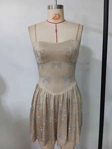 Close-up of sparkling silver rhinestone bow patterns on a champagne evening dress