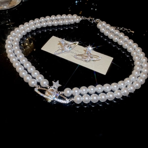 Detailed macro view of double-layer pearl necklace and orb earrings with star details