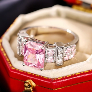 Macro shot of a large rectangular pink gemstone ring set in a red velvet jewelry box