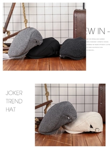 Classic wool blend newsboy caps in grey and black displayed on a rustic wood surface